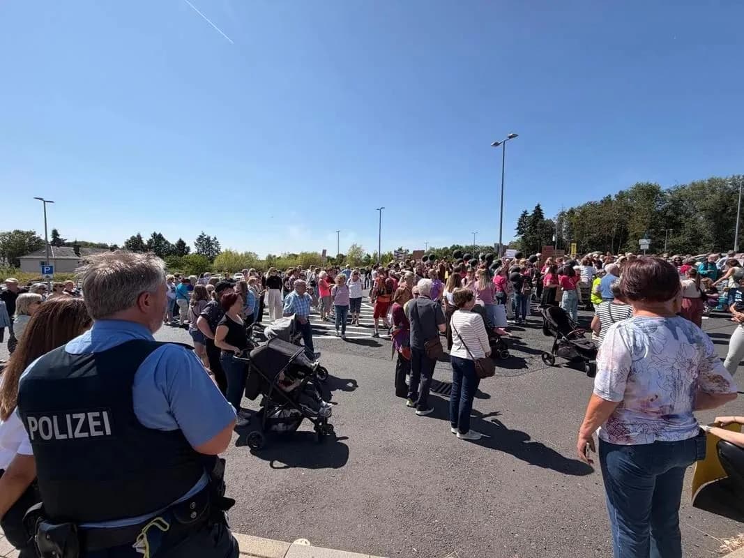 Menschen versammeln sich bei der zweiten Kundgebung in Ziegenhain, im Vordergrund ein Polizist.