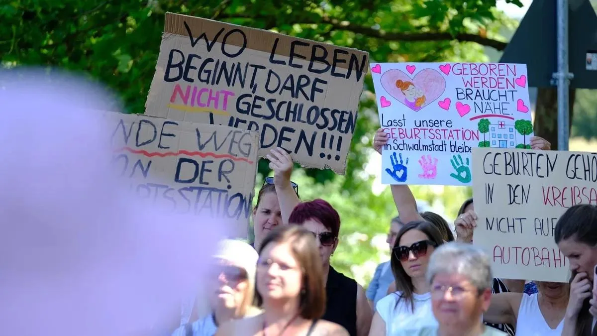 Ein Schild mit der Aufschrift „Wo Leben beginnt, darf nicht geschlossen werden!!!“ ragt über die Menge.